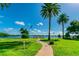 Paved waterfront pathway leads to a private dock with lush landscaping at 1847 Shore S Dr # 614, South Pasadena, FL 33707