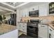 Modern kitchen with white cabinets, granite countertops, and stainless steel appliances at 1847 Shore S Dr # 614, South Pasadena, FL 33707