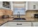 Modern kitchen features granite countertops, white cabinets, and a brick backsplash at 1847 Shore S Dr # 614, South Pasadena, FL 33707