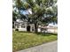 Well-maintained single-story home with a sprawling green lawn, mature trees, and a serene, inviting curb appeal at 8088 Spanish Oak Dr, Spring Hill, FL 34606