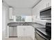 Modern kitchen with white cabinets, granite countertops, and stainless steel appliances at 2424 W Tampa Bay Blvd # L-302, Tampa, FL 33607