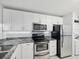 Modern kitchen with white cabinets, granite countertops, and stainless steel appliances at 2424 W Tampa Bay Blvd # L-302, Tampa, FL 33607