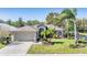 Single-story home with attached garage, landscaped lawn, and mature palm trees at 1533 Westerham Loop, Trinity, FL 34655