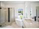 Bright bathroom featuring soaking tub, frameless shower, and marble countertops at 19395 Sheltered Hill Dr, Brooksville, FL 34601