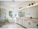 Bright bathroom with double vanity, soaking tub, and glass shower enclosure at 19395 Sheltered Hill Dr, Brooksville, FL 34601