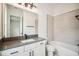 Contemporary bathroom featuring tile flooring, shower/tub combo, and large vanity with gray counter at 19395 Sheltered Hill Dr, Brooksville, FL 34601