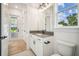 Clean bathroom boasts a modern vanity with a dark countertop, toilet, and window for natural light at 19395 Sheltered Hill Dr, Brooksville, FL 34601