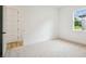 An empty bedroom features neutral carpet, white walls, and a window at 19395 Sheltered Hill Dr, Brooksville, FL 34601