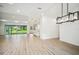 Large empty room with modern lighting, hardwood floors, and glass sliding doors to the backyard at 19395 Sheltered Hill Dr, Brooksville, FL 34601