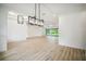 Large empty room with modern lighting, hardwood floors, and glass sliding doors to the backyard at 19395 Sheltered Hill Dr, Brooksville, FL 34601