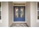 Stylish blue double doors with intricate glass detail framed by neutral siding at 19395 Sheltered Hill Dr, Brooksville, FL 34601