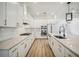 Modern kitchen features white cabinets, stainless steel appliances, gas range, and light countertops and island at 19395 Sheltered Hill Dr, Brooksville, FL 34601