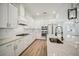 Modern kitchen features white cabinets, stainless steel appliances, gas range, and light countertops with island at 19395 Sheltered Hill Dr, Brooksville, FL 34601