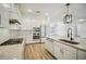 Bright kitchen boasts white cabinetry, modern stainless steel appliances, and a center island with a sink at 19395 Sheltered Hill Dr, Brooksville, FL 34601