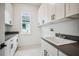 Convenient laundry room featuring a sink, countertop, storage and window for natural light at 19395 Sheltered Hill Dr, Brooksville, FL 34601
