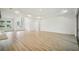 Bright open living room with kitchen, tray ceilings, wood floors and custom light fixtures at 19395 Sheltered Hill Dr, Brooksville, FL 34601
