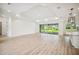 Bright living room with tray ceiling, wood floors, and sliding glass doors to the backyard at 19395 Sheltered Hill Dr, Brooksville, FL 34601
