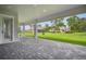 Spacious, covered patio with brick pavers offers a relaxing outdoor space with views of the grassy backyard at 19395 Sheltered Hill Dr, Brooksville, FL 34601