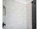 A modern shower featuring neutral tile and a black tile accent wall at 19395 Sheltered Hill Dr, Brooksville, FL 34601