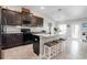 Kitchen with island, dark cabinets, and white backsplash at 14937 Potterton Cir, Hudson, FL 34667