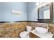 Modern bathroom with stone tile, vessel sink, and mirror at 41 Cypress Dr, Palm Harbor, FL 34684