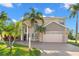 Two-story house with a beige exterior, brick accents, and a two-car garage at 41 Cypress Dr, Palm Harbor, FL 34684
