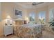 Bright bedroom with a floral comforter, white nightstands, and bay window at 9312 Gentle Ben Ct, Weeki Wachee, FL 34613