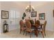 Well-lit dining area, featuring a wood table, chairs, and plantation shutters at 9312 Gentle Ben Ct, Weeki Wachee, FL 34613