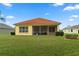 House with a screened patio and a well-maintained lawn at 9312 Gentle Ben Ct, Weeki Wachee, FL 34613
