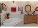 Bathroom boasts a corner soaking tub, granite countertops, and wood cabinets at 9312 Gentle Ben Ct, Weeki Wachee, FL 34613