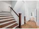Wooden staircase with white risers and dark wood handrail at 321 S Brooksville Ave, Brooksville, FL 34601