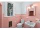 Pink tiled bathroom with pedestal sink and vintage style at 321 S Brooksville Ave, Brooksville, FL 34601