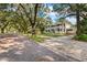 Two-story house on a tree-lined street with a brick driveway at 321 S Brooksville Ave, Brooksville, FL 34601