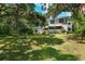 House's backyard with lush lawn and mature trees at 321 S Brooksville Ave, Brooksville, FL 34601