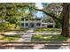 Two-story house with a wrap-around porch and mature trees at 321 S Brooksville Ave, Brooksville, FL 34601