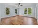 Large bedroom with hardwood floors, ceiling fan, and multiple windows at 321 S Brooksville Ave, Brooksville, FL 34601
