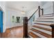 Bright entryway with hardwood floors, chandelier, and staircase with wooden railing at 321 S Brooksville Ave, Brooksville, FL 34601