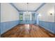 Bright dining room with hardwood floors, chandelier, and blue wainscoting at 321 S Brooksville Ave, Brooksville, FL 34601
