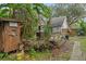 Rustic backyard with shed, wood pile, and overgrown landscaping at 14335 Snow Memorial Hwy, Brooksville, FL 34601