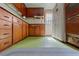 Retro kitchen with wood cabinets and green flooring at 14335 Snow Memorial Hwy, Brooksville, FL 34601