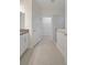Clean bathroom featuring a glass-enclosed shower, tiled floors, and a view into the walk-in closet at 11512 Weaver Hollow Rd, New Port Richey, FL 34654