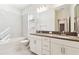 Well-lit bathroom features double sinks, gray countertops, and a white tiled tub-shower combo at 11512 Weaver Hollow Rd, New Port Richey, FL 34654