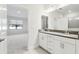 Bright bathroom with double vanity, modern fixtures, and view into bedroom at 11512 Weaver Hollow Rd, New Port Richey, FL 34654
