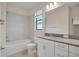 Bright bathroom featuring a shower-tub, and a white vanity with a gray countertop at 11512 Weaver Hollow Rd, New Port Richey, FL 34654