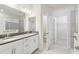 Bright bathroom features a double vanity, linen closet, and a separate area for the toilet and shower at 11512 Weaver Hollow Rd, New Port Richey, FL 34654