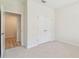 Bedroom features carpeted flooring, closet doors, and doorway to hallway at 11512 Weaver Hollow Rd, New Port Richey, FL 34654
