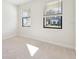 Bright bedroom features neutral carpet, light walls, and two windows overlooking the neighborhood at 11512 Weaver Hollow Rd, New Port Richey, FL 34654