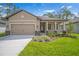 Attractive home with a two-car garage, well-kept lawn, and a covered entryway with stone details at 11512 Weaver Hollow Rd, New Port Richey, FL 34654