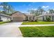 Charming single-story home featuring a well-maintained lawn and a covered entryway with stone columns at 11512 Weaver Hollow Rd, New Port Richey, FL 34654