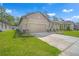 Beautiful single-story home with a two-car garage, manicured lawn, and stone accent columns at 11512 Weaver Hollow Rd, New Port Richey, FL 34654